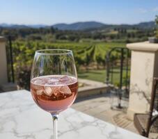 Pink Sparkling Wine on Marble Table Overlooking Vineyard photo