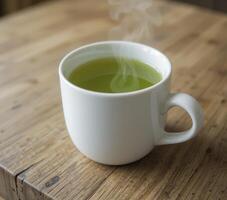 Steaming Cup of Green Tea on Rustic Wooden Table photo