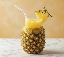 Refreshing Pineapple Juice in a Pineapple Cup on Marble photo