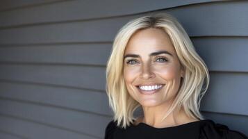 Smiling Person in Dark Top Against Gray Wood photo