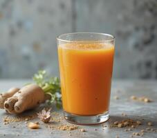 Vibrant Orange Juice with Ginger and Turmeric on Gray Background photo