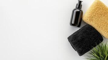 Amber Bottle Of Liquid Soap With Black And Beige Towels On White photo