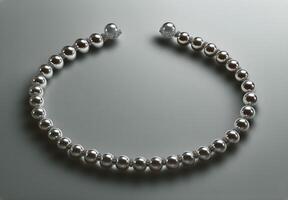 Elegant Silver and Pearl Necklace Displayed on a Smooth Surface Capturing Soft Light Reflections photo
