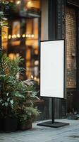 Blank Sign Board Outside a Cafe With Plants in a Lively Urban Area During Daylight photo