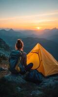 Setting up Camp at Sunset on a Mountain With a Vibrant Sky and a Cozy Tent photo