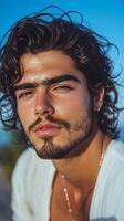 Young Man With Curly Hair Poses Near the Shore During Sunset photo
