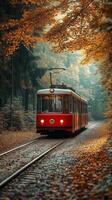 Vintage Red Tram Travels Through Autumn Forest Path Surrounded by Colorful Foliage photo
