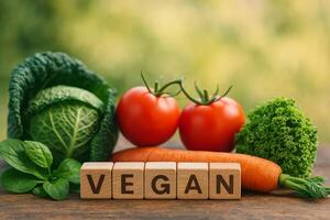 Fresh Vegetables and Wooden Blocks Spell Vegan During a Sunny Day in a Natural Setting photo