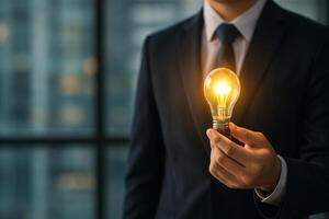 Business Professional Holding Glowing Light Bulb in Modern Office at Dawn photo