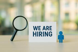 Hiring Campaign With a Sign and Figure on a Desk in a Modern Office photo