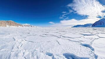 An ice field with snow and mountains in the background photo