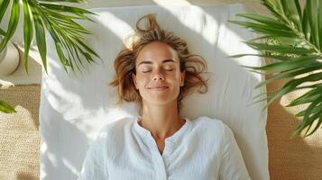 A woman is lying on a bed with her eyes closed photo
