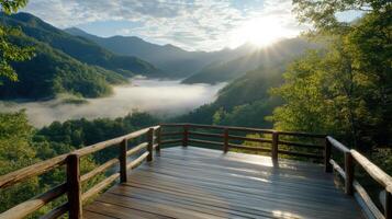 Wooden bridge over a valley with trees and fog photo