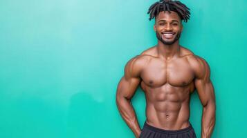 A man with a muscular body standing in front of a green wall photo