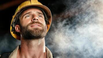 A man in a hard hat and beard is looking up photo
