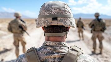 A soldier is walking in the desert with other soldiers photo