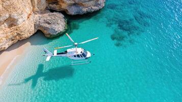 A helicopter is flying over a beach near a cliff photo