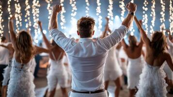 A man in a white shirt and white pants is dancing with his arms up photo