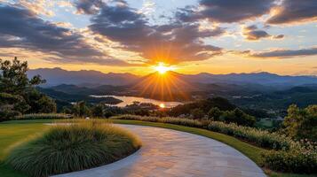 The sun sets over a golf course and mountains photo