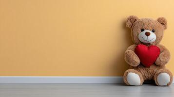 A teddy bear with a heart sitting against a wall photo