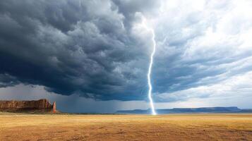 Lightning strikes over a desert landscape with a mountain in the background photo