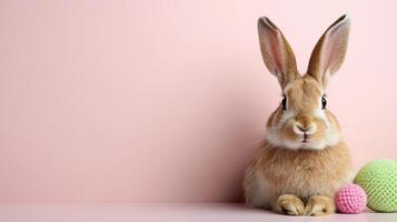 A rabbit is sitting next to a bunch of colorful eggs photo