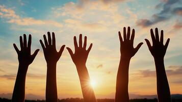 Hands raised up in the air at sunset photo