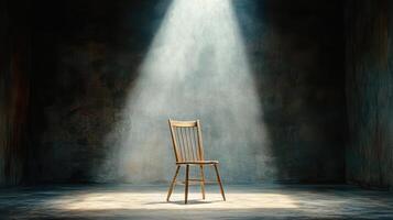 A chair in an empty room with light shining from the ceiling photo