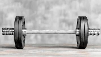 A dumbbell on a table with a gray background photo