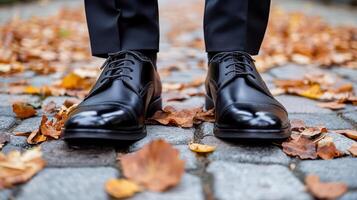 A man in black shoes standing on a cobblestone path photo