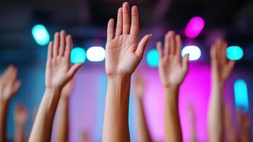 Many hands raised in the air at a concert photo