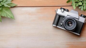 A camera and some leaves on a wooden table photo