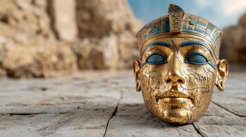 An ancient egyptian mask is on the ground photo