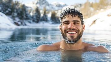 A man smiling in the water with snow covered mountains in the background photo