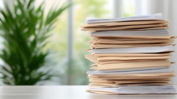 Stack of papers on a table in front of a window photo