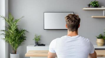 A man sitting in front of a tv watching a show photo