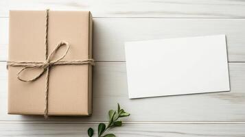 Gift box with twine and blank card on white wooden background photo