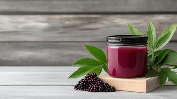 A jar of black currant jam with a green leaf on a wooden table photo