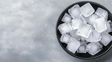 A bowl filled with ice cubes on a gray surface photo