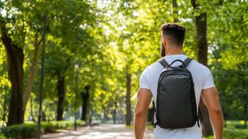 A man with a backpack walking through a park photo