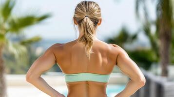 A woman in a bikini top standing by a pool photo