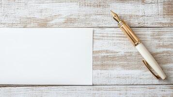 Blank white paper with gold pen on wooden table photo