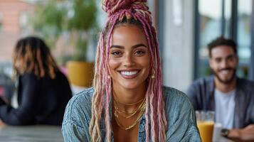 A woman with pink dreadlocks smiling at the camera photo