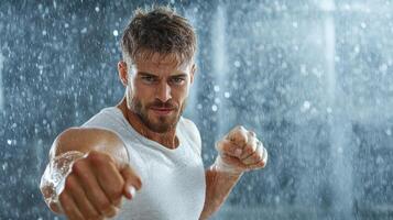 A man in a white tank top is fighting in the rain photo