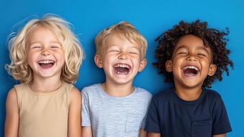 Three children laughing and smiling on a blue background photo