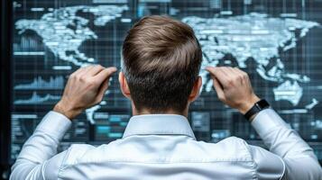 Businessman looking at a world map on a computer screen photo