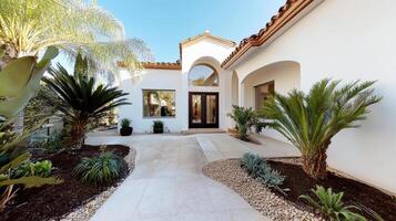 A beautiful home with a walkway and palm trees photo