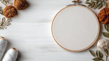 A white embroidery hoop with yarn and spools on a wooden table photo