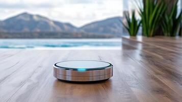 A robotic vacuum cleaner on the floor in front of a mountain view photo