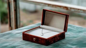 A small silver necklace is sitting in a box photo
